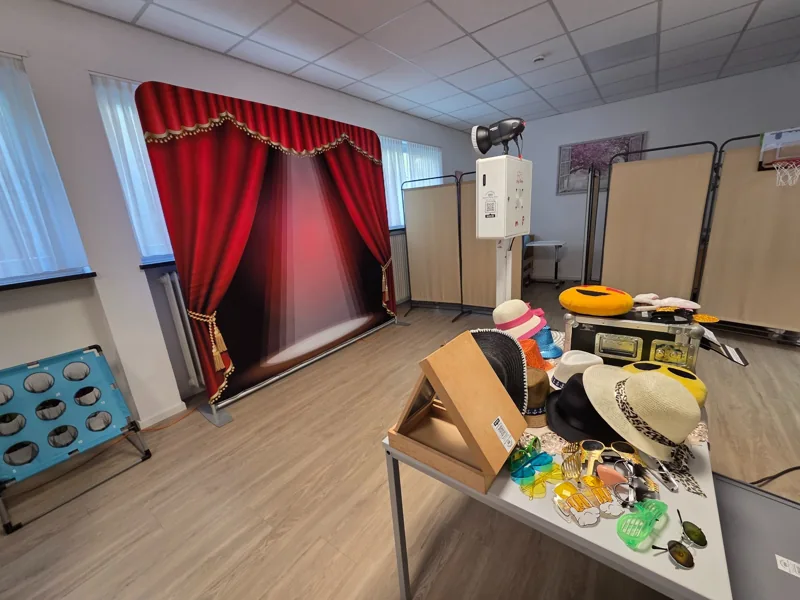 Fotobox mit roter Bühnenrückwand und Requisiten in einer Tagesbetreuung in Emmersweiler