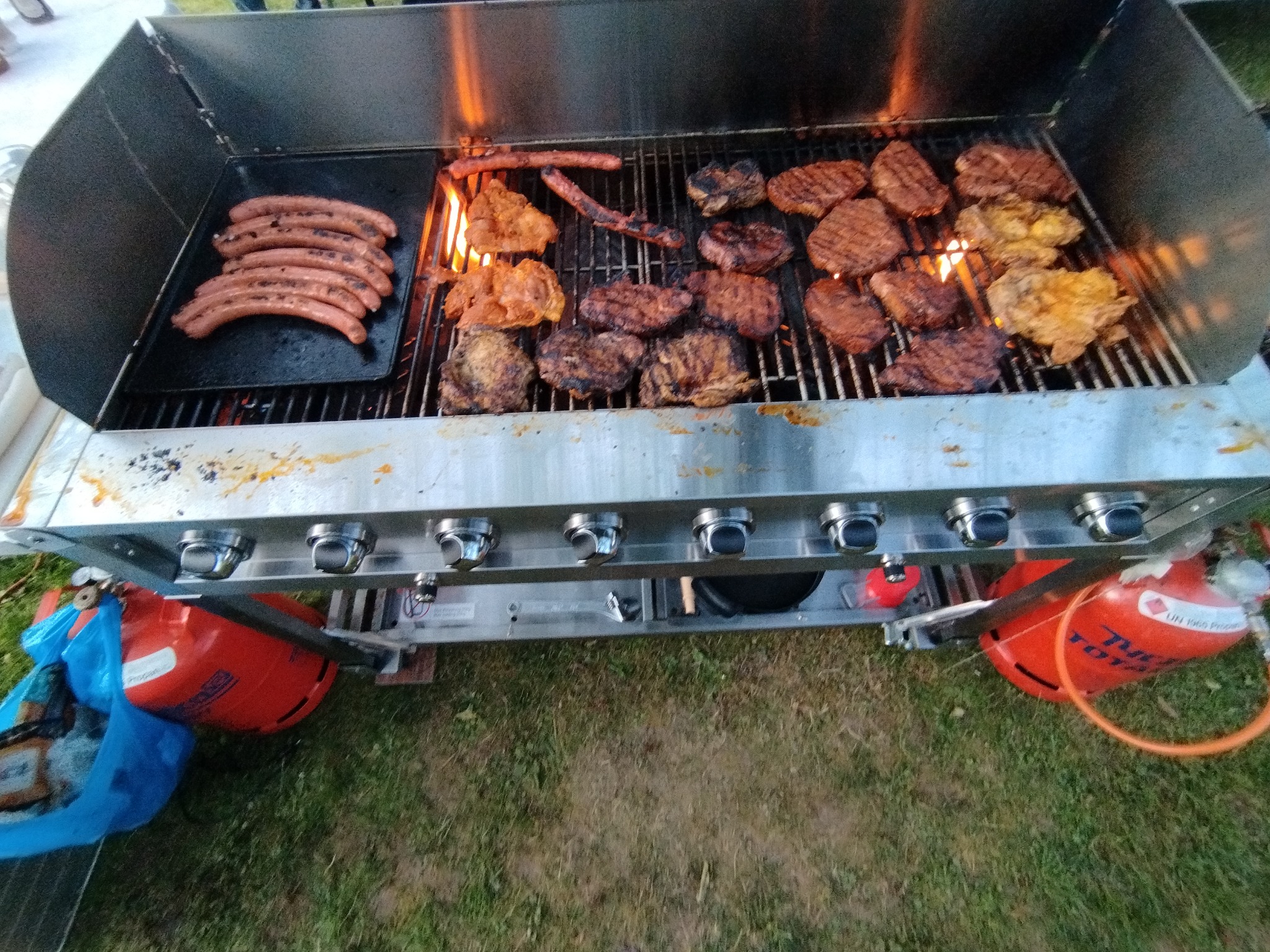8-Brenner-Gasgrill mit Würstchen und Steaks im Einsatz