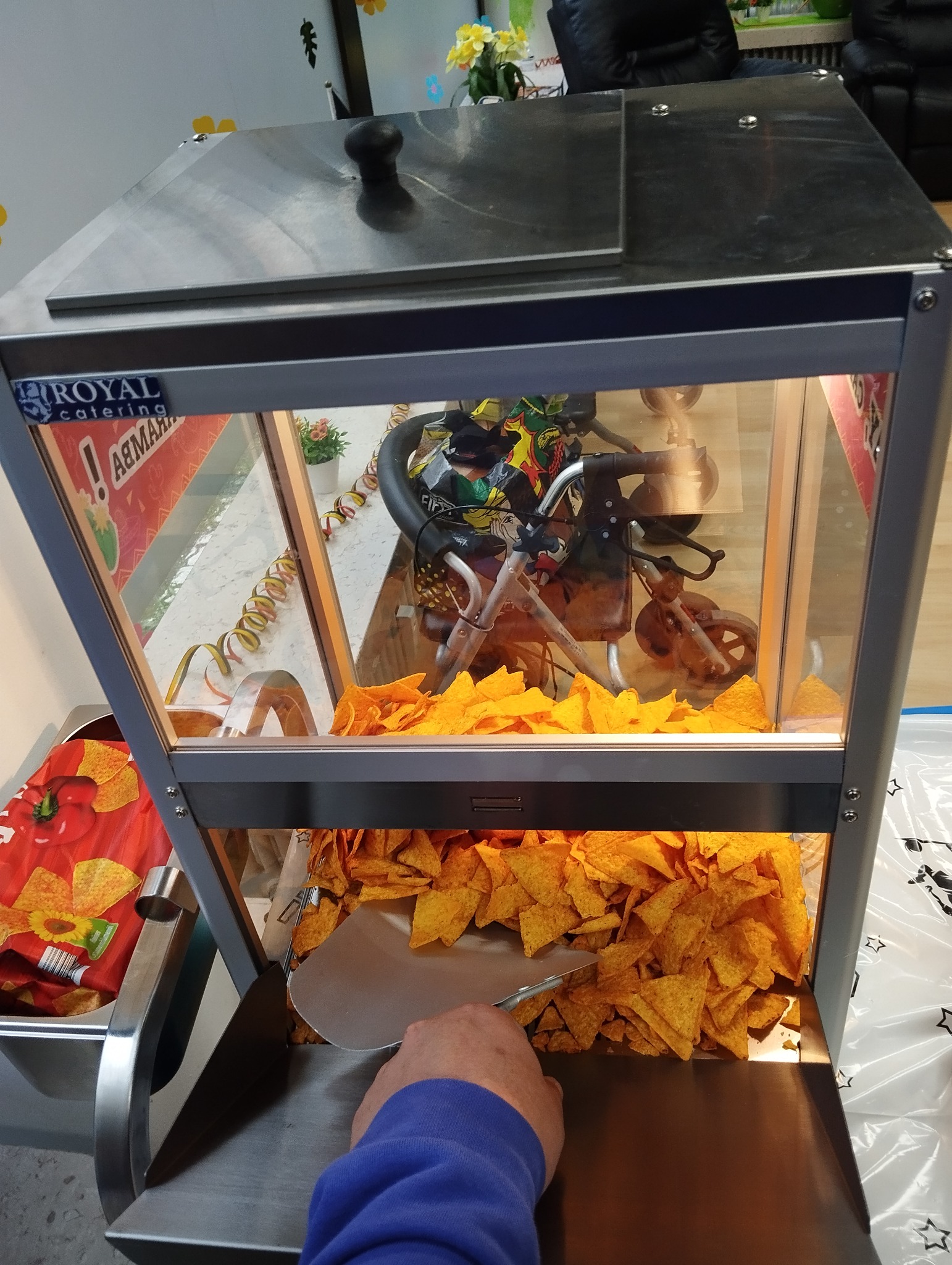Nachos werden aus dem Nacho-Wärmer portioniert